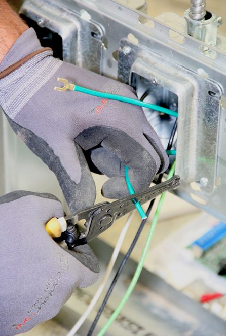 Close-up of a Benson Electric electrician wiring a receptacle