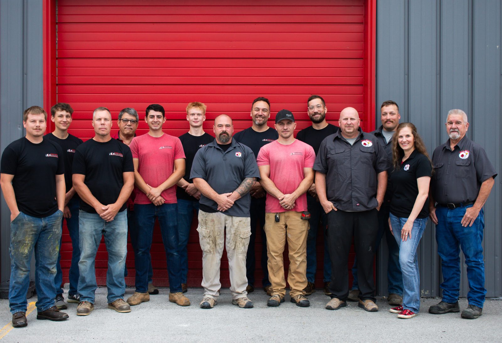 The full Big Birge Plumbing crew in front of their red shop door in Omaha