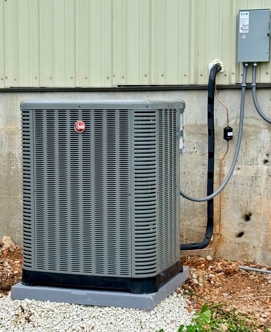 New Rheem condenser installed beside a Northwest Arkansas home