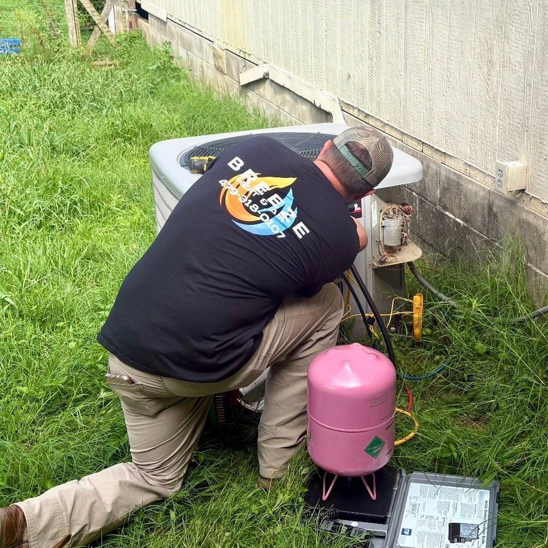 Breeze technician recharging an AC system on a service call