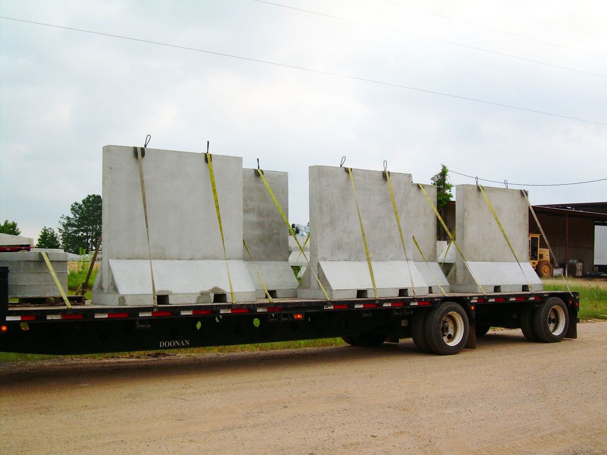 Concrete safety barriers strapped to a flatbed trailer