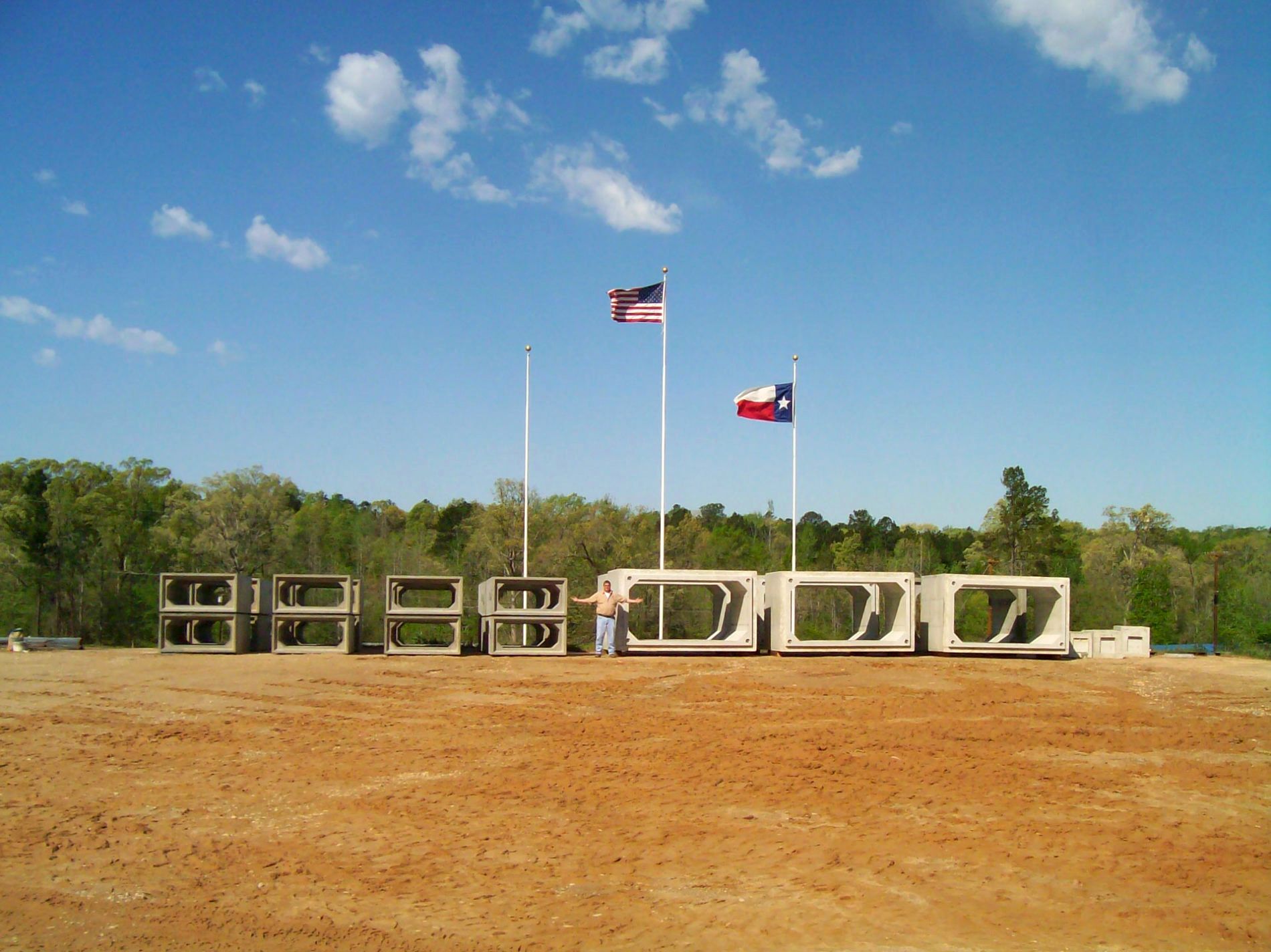Del Zotto box culverts lined up in the Texas yard under the American and Texas flags