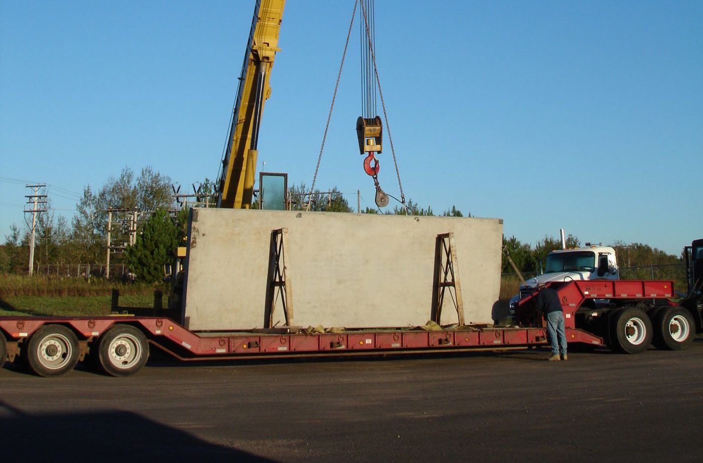 Crane setting a Del Zotto precast wall panel onto a lowboy trailer