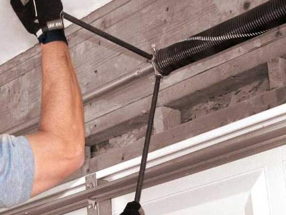 Technician replacing a garage door torsion spring