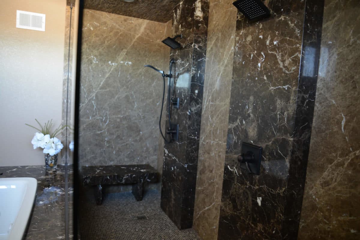 Custom natural stone shower surround fabricated by Granite Works