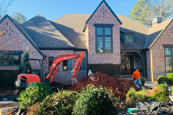 GRC Waterproofing crew and excavator digging out a foundation at a brick home in Middle Georgia
