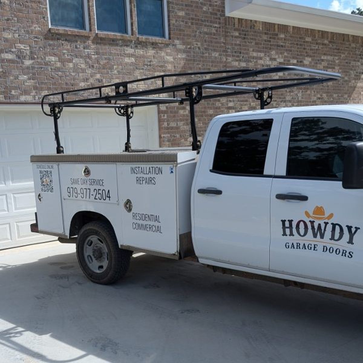 Howdy Garage Doors service truck parked in a College Station driveway