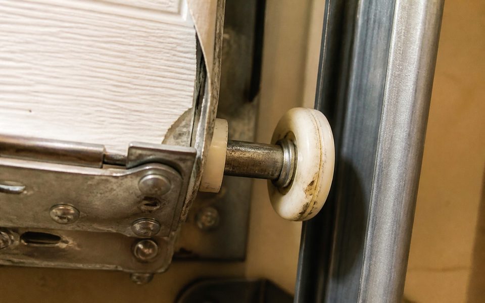 Worn garage door roller and hinge plate causing a noisy door