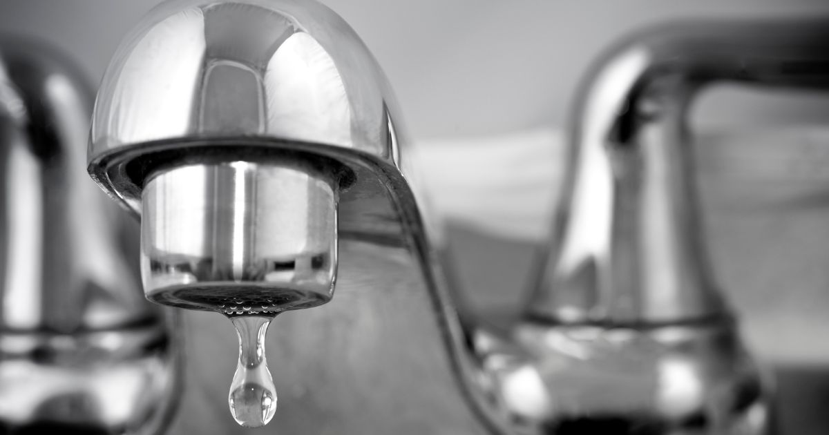 Plumber repairing a kitchen faucet