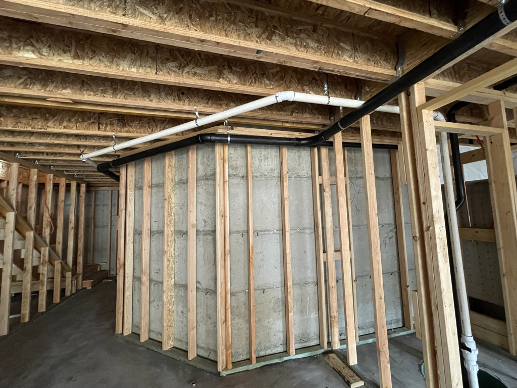 Rough-in plumbing through framed walls in a production home