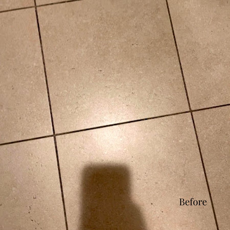 A dull, soiled hotel bathroom tile floor