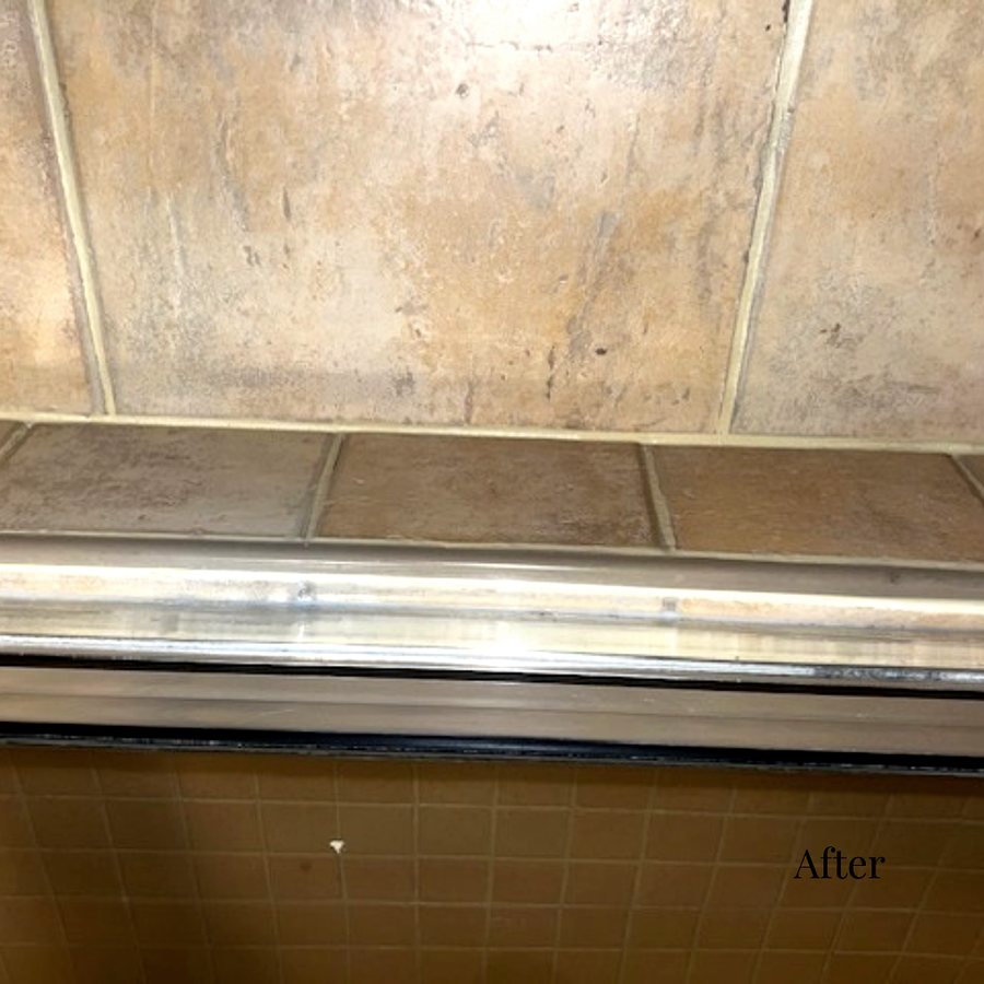 A clean, resealed shower door track in a hotel bathroom