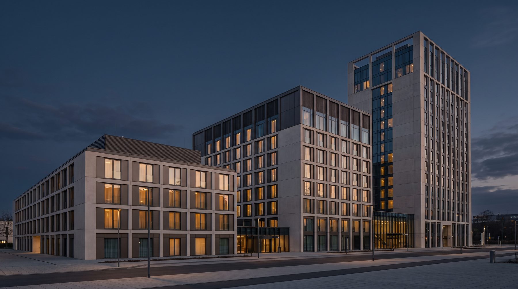 Hotel buildings at dusk with guest room windows lit