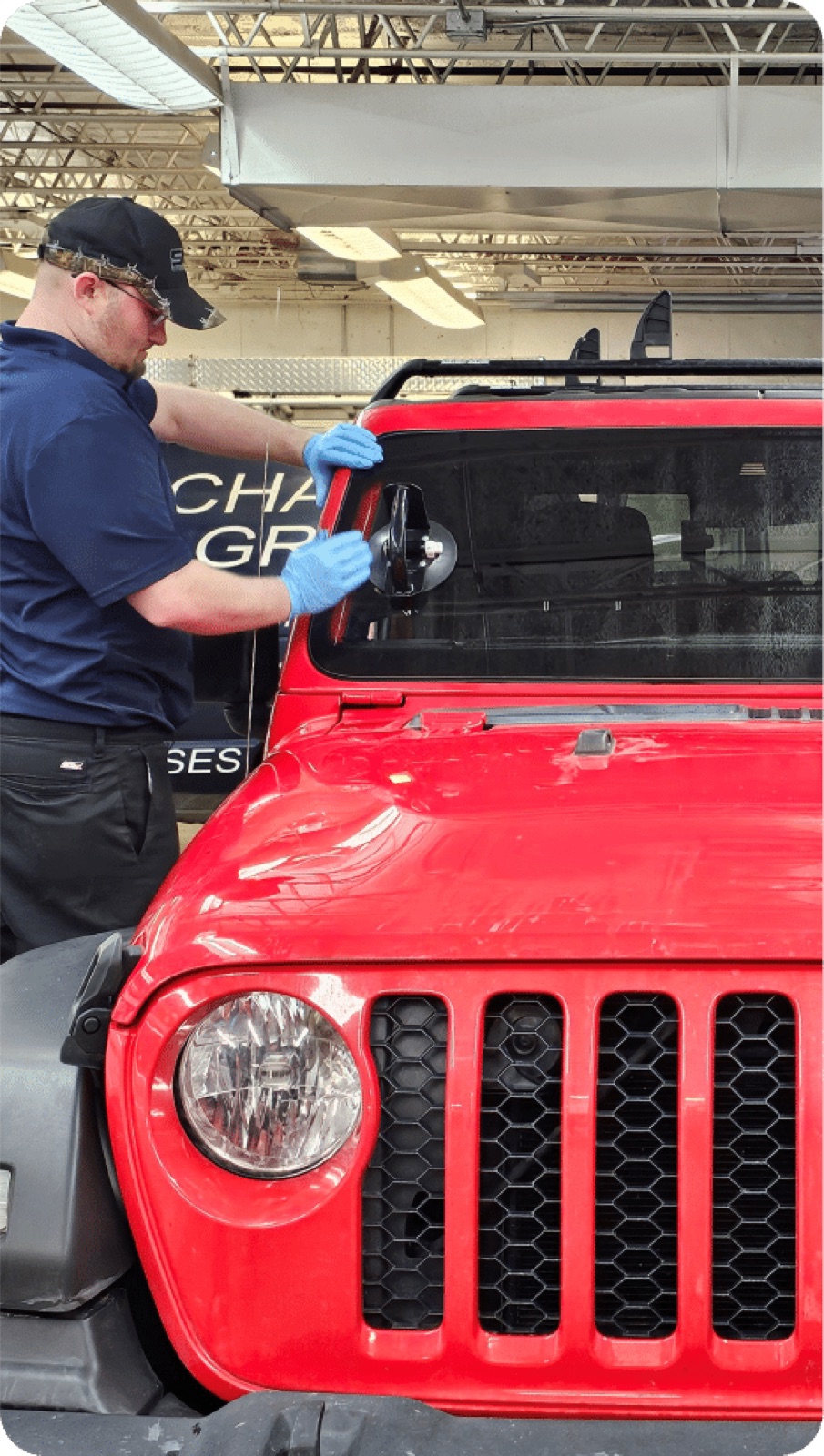 SGI Auto Glass technician installing a windshield on a red Jeep