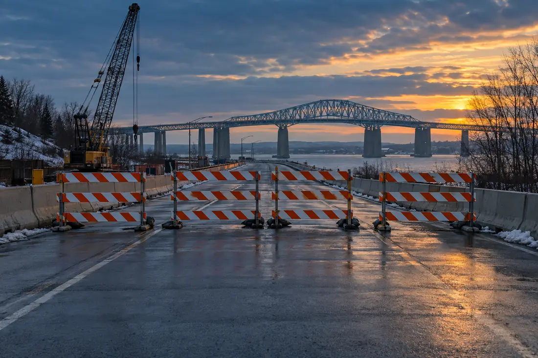 Construction barricades across the bridge approach at dusk