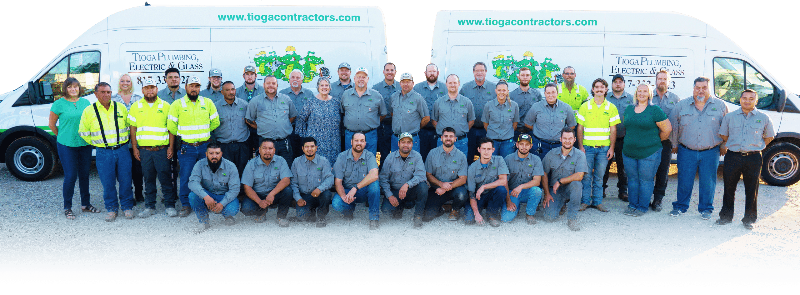 The Tioga Plumbing & Electric team of more than 30 in front of two branded service vans