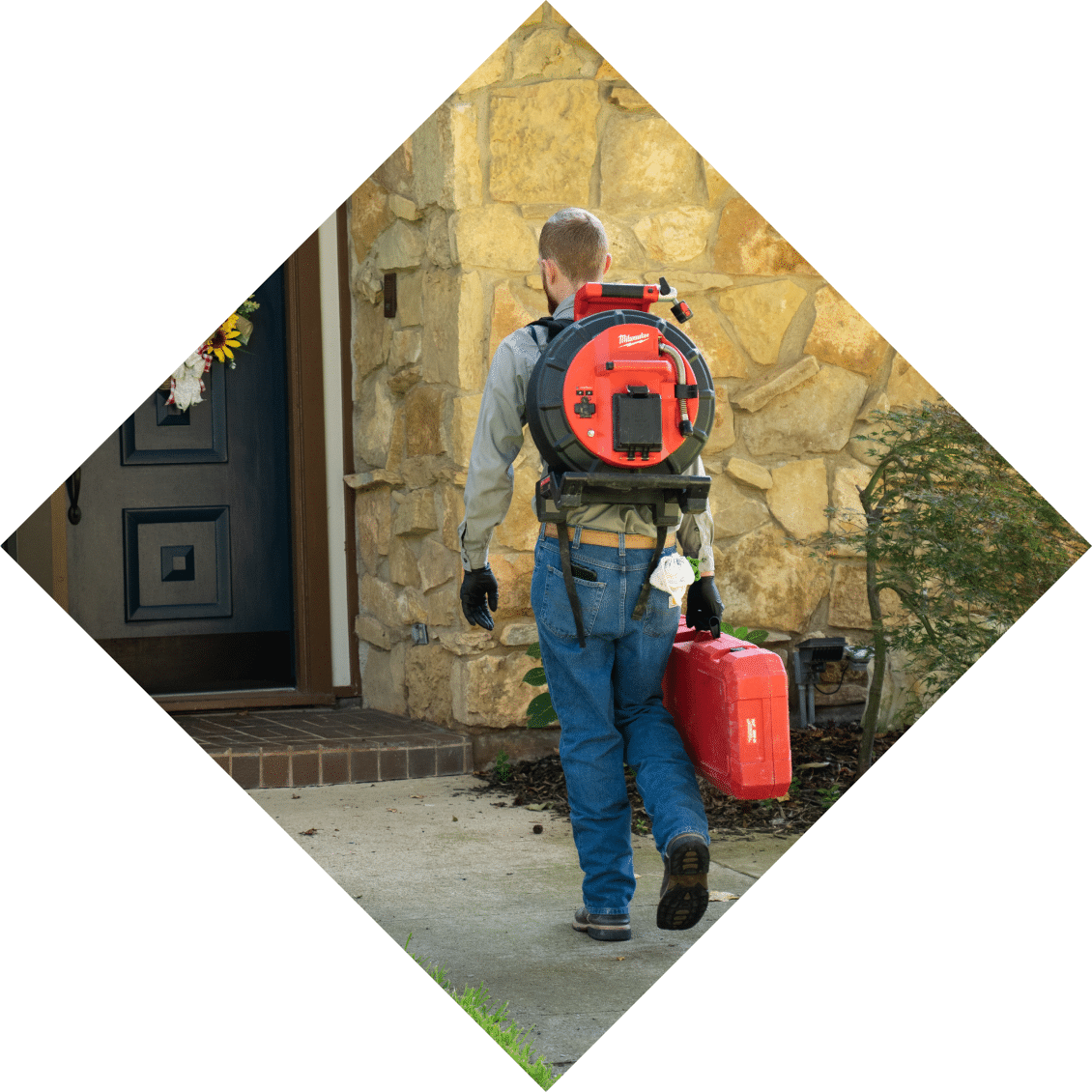 A Tioga technician arriving at a customer's front door with drain camera equipment