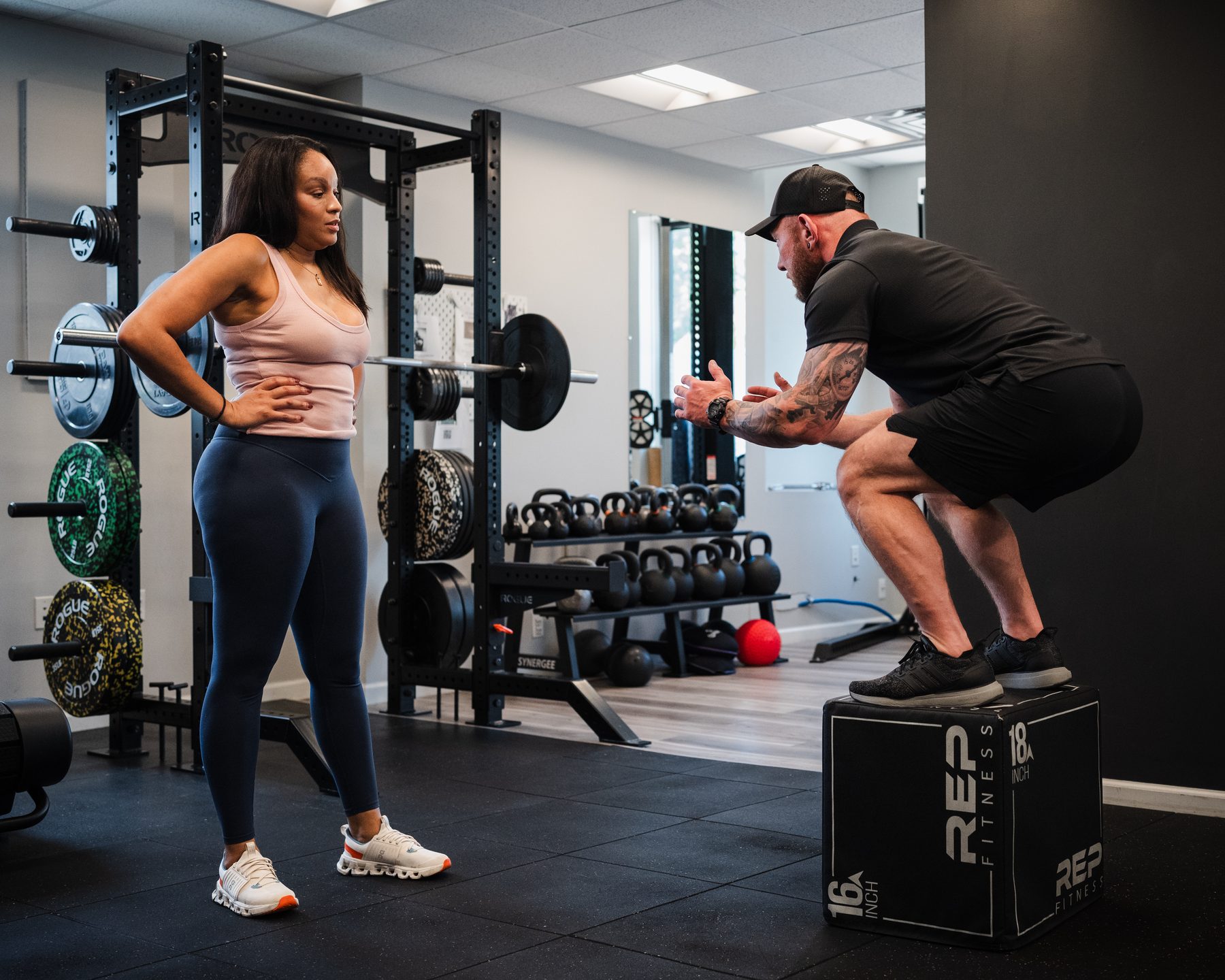 Tom coaching a client through a box squat in the private studio
