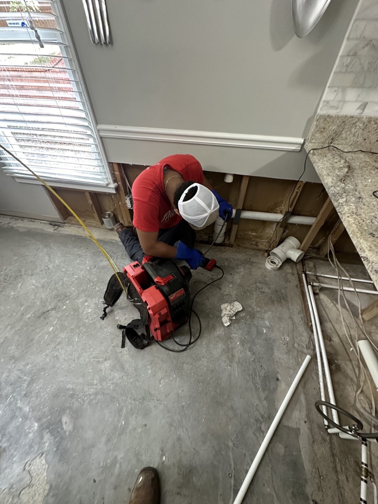 Technician clearing a kitchen drain line